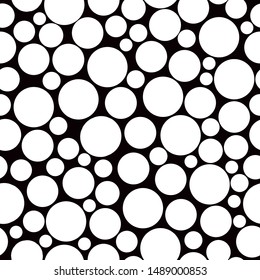 A simple pattern of circles. Black background, large and small white circles, dots . The print is well suited for textiles, packaging and Wallpaper.