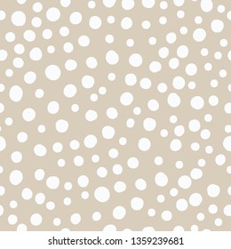 A simple pattern of dots. Beige background, white dots,spots,snow . The print is well suited for textiles,banners, postcards and Wallpapers.