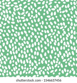Simple pattern of spots. Abstraction. Green background, white spots, snow. The print is well suited for textiles, banners, postcards, Wallpaper and packaging.