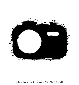 Simple photo camera. Technology icon. Black ink with splashes on white background