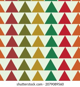 Simple retro triangles seamless pattern in red, green, orange, beige over light cream background. Great as winter and Christmas background, home décor, textile and wallpaper.    