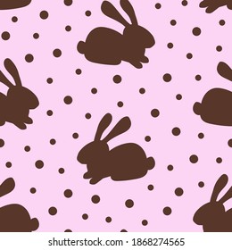 Simple vector seamless polka dot pattern. Chocolate bunny on a pink background. For prints of fabrics, textile products, packaging design. Sweets, dessert.