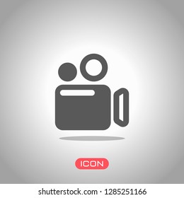 Simple video camera icon. Icon under spotlight. Gray background