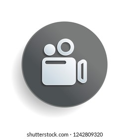 Simple video camera icon. White paper symbol on gray round button or badge with shadow