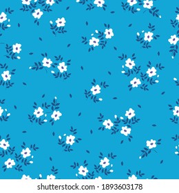 Simple vintage pattern. Small white flowers. Bright blue background. Fashionable print for wallpaper and textiles. Vector image.