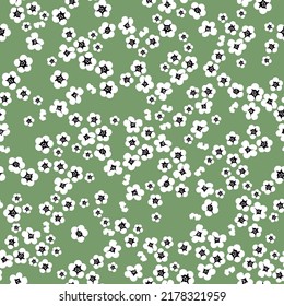 Einfaches Vintage-Muster. kleine weiße Blumen. grüner Hintergrund. Modedruck für Textilien und Tapeten.
