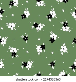 Patrón vintage simple. flores blancas y negras, hojas y puntos. fondo verde. Impresión de moda para textiles y papel pintado.