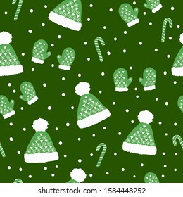 Simple winter pattern .Green background, cute green mittens and hats with patterns, snow, candy cane. The print is well suited for Wallpaper, postcards, banners and packaging.