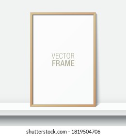 Simple wooden frame standing on a shelf. Blank elegant frame leaning against the white wall. Picture frame vector mockup.