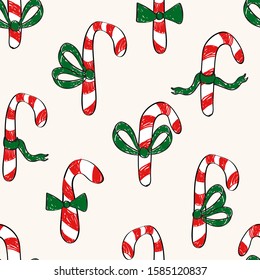 Simplistic Christmas seamless half drop repeat pattern with hand drawn sketched doodled candy canes with green bow ties on a cream background 