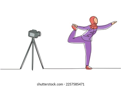 Single continuous line drawing Arab woman blogger in hijab sportswear shoots video on camera doing exercises at home. Fitness vlogger live broadcast of training session. One line draw design vector