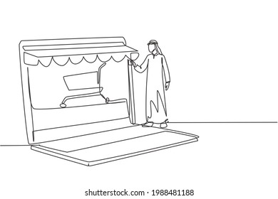 Single continuous line drawing Arabian man inserting credit card into canopy laptop screen with shopping cart. E-shop, digital payment concept. Dynamic one line draw graphic design vector illustration