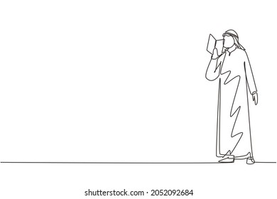 Single continuous line drawing Arabian guy standing and reads book that holds in one hand. Young man love to read. Male students with open books in hands. One line draw design vector illustration