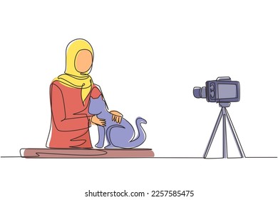 Single continuous line drawing Arabian vet blogger sitting in front of camera with cats and recording video blog about animals. Zoo psychologist creating content for vlog one line draw design vector