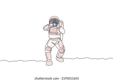 Single continuous line drawing astronaut doing photography with dslr camera in moon surface. Having fun in leisure time on outer space concept. Trendy one line draw design vector illustration graphic