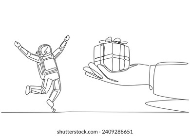 Single continuous line drawing astronaut excited to get the gift box from the giant hand. Neatly wrapped in cardboard. Decorated with ribbon. Special gift. Success. One line design vector illustration