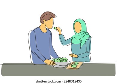 Single continuous line drawing beautiful Arab wife feeds her husband food   in front him is bowl filled and salad  Cooking together in kitchen  One line draw graphic design vector illustration