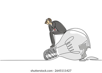 Línea continua única que dibuja un hombre de negocios se sienta en una bombilla rota con ambas manos sostiene la cabeza. Ideas que no se implementaron. Día Nacional de la Creatividad. Ilustración vectorial de diseño de una línea