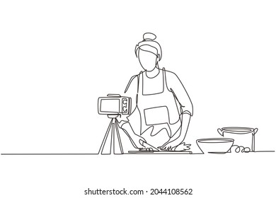 Single continuous line drawing food blogger. Chef cooking, recording video using camera. Online channel, stream. Woman teaches cooking new recipe. Culinary show. One line draw graphic design vector