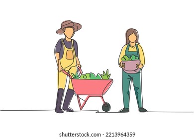 Single continuous line drawing happy couple farmer with wheelbarow trolley and basket full of fruits. A successful harvest activity minimalism concept. One line draw graphic design vector illustration