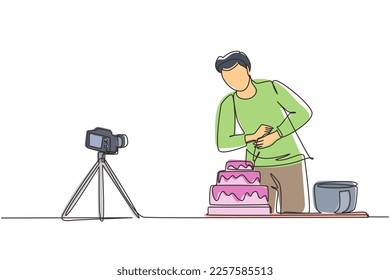 Single continuous line drawing influencer or food blogger creating content. Man shooting cooking video using camera on tripod. Chef baking and decorating cake at kitchen. One line draw design vector