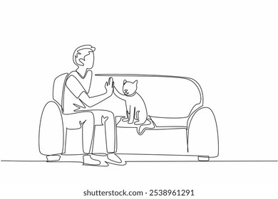 Single continuous line drawing man sitting on sofa with his cat while giving high five. Educated to be an obedient animal. Favorite pet. Bonding. National Pet Day. One line design vector illustration