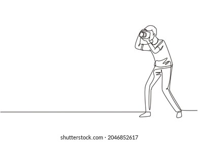 Un fotógrafo de dibujo de línea continua haciendo pose fotográfica. Cámara y operador profesional, hombre corresponsal. Hombre con cámara haciendo fotos. ilustración vectorial de diseño gráfico de una línea
