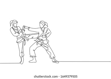 Single continuous line drawing of two young confident karateka girls in kimono practicing karate combat at dojo. Martial art sport training concept. Trendy one line draw design vector illustration