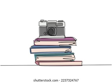 Single continuous line drawing of vintage classic analog pocket camera above stack of books on desk. Old retro photography equipment concept. One line draw design graphic vector illustration