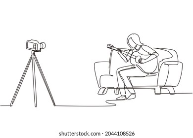 Single continuous line drawing woman blogger recording and live steam playing guitar on social media. Concept of guitarist online lesson while stay at home. One line draw design vector illustration