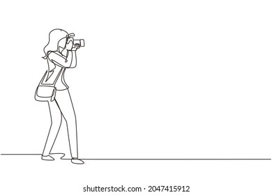 Single continuous line drawing woman photographer holding photo camera and photographing. Creative profession or occupation. Happy female take photo shot. One line draw design vector illustration