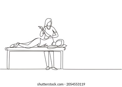 Single continuous line drawing woman patient lying on massage table therapist doing healing treatment massaging injured hand manual physical therapy rehabilitation concept. One line draw design vector