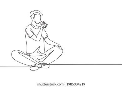 Single continuous line drawing young man sitting while enjoying a soft drink to refreshing and relaxing body. Attractive teenager concept. Dynamic one line draw graphic design vector illustration