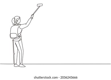 Single continuous line drawing young girl with backpack standing and taking selfie photo on her smart phone. Summer activity at nature. Travel blogger. One line draw graphic design vector illustration