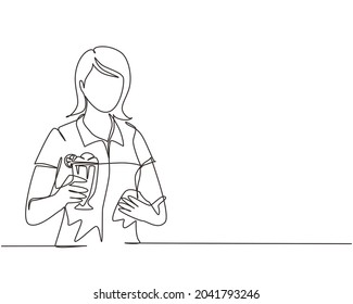Single continuous line drawing young girl holding and showing glass of milkshake in office. Attractive lady having break at work and drink milkshake with slice of orange. One line draw design vector