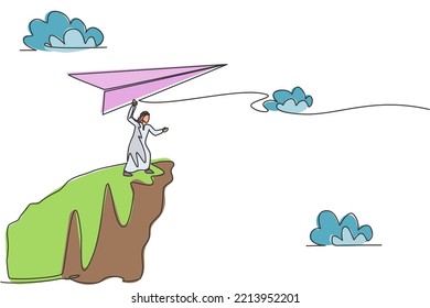 Single continuous line drawing young Arab business man fly paper plane from top of mountain. Professional manager. Minimalism metaphor concept. Dynamic one line draw graphic design vector illustration