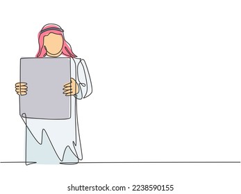 Single continuous line drawing of young muslim businessman showing white paper board to audience. Arab middle east cloth shmagh, kandura, thawb, robe. One line draw design vector graphic illustration