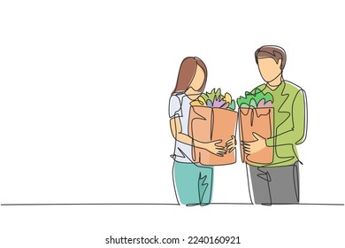 Single continuous line drawing young happy couple holding grocery paper bag after shopping at grocery store together. Buying daily goods concept. One line draw vector graphic design illustration