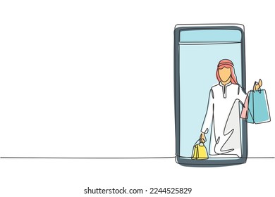 Single continuous line drawing young Arab man coming out of smartphone screen holding shopping bags. Digital lifestyle and consumerism concept. Dynamic one line draw graphic design vector illustration