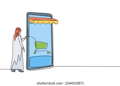 Single continuous line drawing young Arab man inserting credit card into canopy smartphone screen with shopping cart. Digital payment concept. Dynamic one line draw graphic design vector illustration