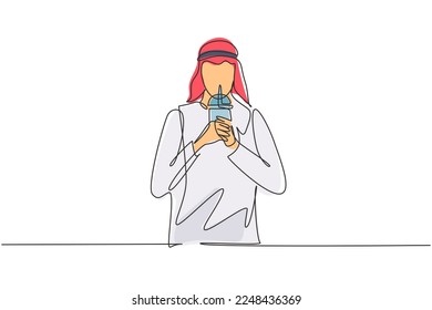 Single continuous line drawing young Arabian male hold plastic cup and drink iced green tea with straw. Make him refreshing in summer season. Dynamic one line draw graphic design vector illustration