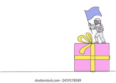 Single continuous line drawing young energetic astronaut standing on giant gift box holding fluttering flag. Bring gifts containing space materials for the team on earth. One line vector illustration