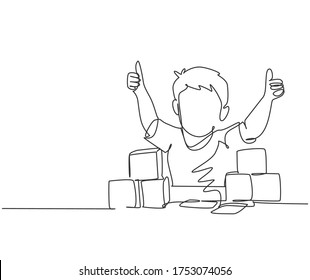 Single line drawing of young happy boy playing stack of puzzle block on table and giving thumbs up gesture in kindergarten class. Business deal continuous line draw design graphic vector illustration