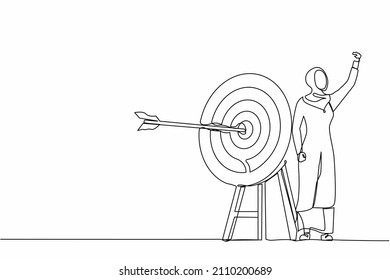 Single one line drawing Arab businesswoman fist pump her arrow directed into target. Target goal, focus, progress. Business archery, arrow hit focus. Continuous line design graphic vector illustration