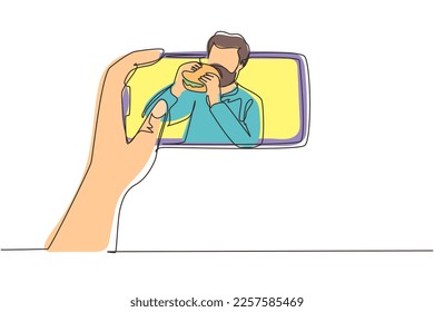 Single one line drawing Arab male food blogger eating burger while creating new video stream for his channel with smartphone. Food concept. Gastronomy. Continuous line draw design vector illustration
