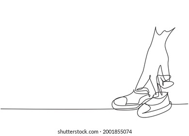 Single one line drawing baby shoes are worn by young mothers' fingers  Beautiful shoes for cute little babies  Happy family concept  Modern continuous line draw design graphic vector illustration