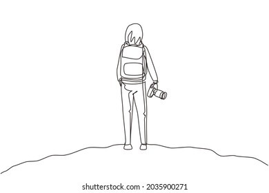 Single one line drawing back view woman holding camera standing on hill of mountain in forest landscape view with sunset. Young tourist photographer. Continuous line draw design vector illustration