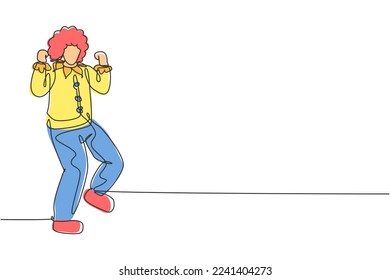 Single one line drawing clown stands with celebrate gesture wearing wig and clown costume ready to entertain audience in circus arena. Modern continuous line draw design graphic vector illustration