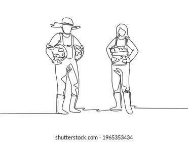 Single one line drawing of couple farmer carrying a basket full of fruit with both they hands from the harvest. Farming minimalism concept. Continuous line draw design graphic vector illustration