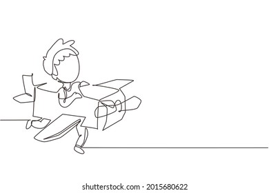 Single one line drawing creative boy playing as pilot with cardboard airplane. Happy kids riding cardboard handmade airplane. Plane game. Modern continuous line draw design graphic vector illustration